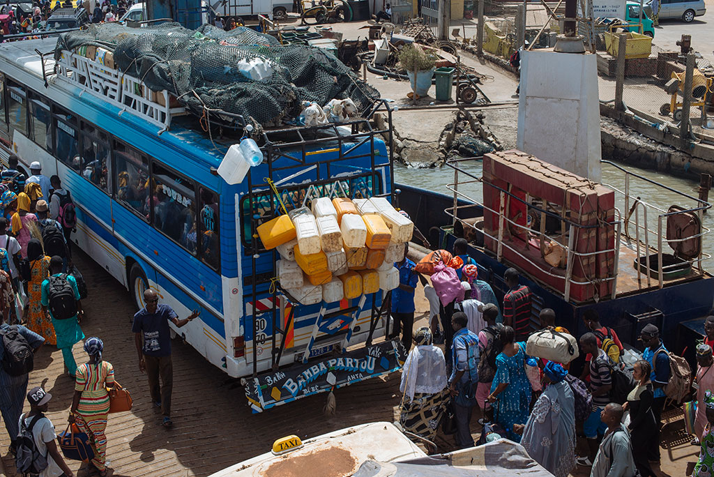 Camiones y pasajeros subiendo al ferri de Banjul a Barra